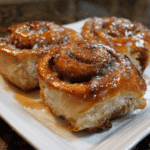 Gluten free cinnamon roll served on a plate with fork and linen napkin